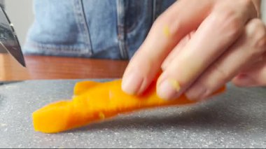 Mutfakta kaynamış havucu doğrayan kadının videosunu kapat. Sağlıklı sebze hazırlama, pişirme süreci, ev yapımı yemek, vejetaryen yemeği, aşçılık konsepti