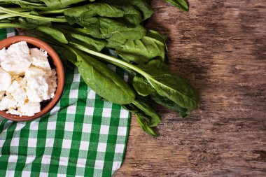 Taze ıspanak ve peynir ahşap arka plan üzerinde.