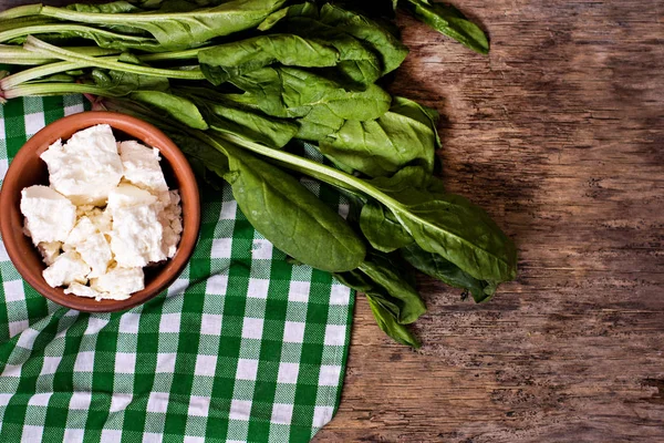 Taze ıspanak ve peynir ahşap arka plan üzerinde.