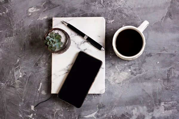 Not defteri, cep telefonu, kalem, etli, Gözlük, gri çimento arka plan üzerinde kahve. İş kavramı.