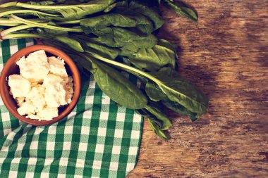 Taze ıspanak ve peynir ahşap arka plan üzerinde.