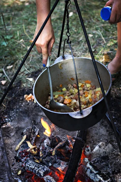 A pot of meat over a fire. Hike, summer vacation, outdoor recreation, outdoor food. Cooking over a campfire. tourist kettle over campfire.