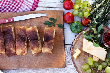 Peynir ve kurutulmuş domates ile meyveli turta. Akşam yemeği için sofrayı. Öğle Yemeği. Ev yapımı pasta, turta ve aperatifler, sebze, meyve, peynir.