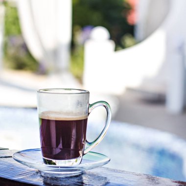 Bir fincan espresso ve bir havuz ve bir beyaz arka planda bina. Sabah kahve. Yaz kahvaltı. Kahve Resort.