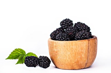 Bramble beyaz zemin üzerine bir kase. İzole et. Böğürtlen kopya alanı metin için ahşap bir kase. Olgun ve lezzetli siyah dut üzerinde beyaz izole. Beyaz bir arka plan üzerinde böğürtlen. 