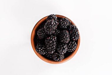 Bramble beyaz zemin üzerine bir kase. İzole et. Böğürtlen kopya alanı metin için ahşap bir kase. Olgun ve lezzetli siyah dut üzerinde beyaz izole. Beyaz bir arka plan üzerinde böğürtlen. 