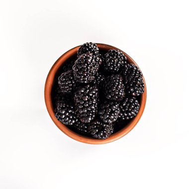 Bramble beyaz zemin üzerine bir kase. İzole et. Böğürtlen kopya alanı metin için ahşap bir kase. Olgun ve lezzetli siyah dut üzerinde beyaz izole. Beyaz bir arka plan üzerinde böğürtlen. 