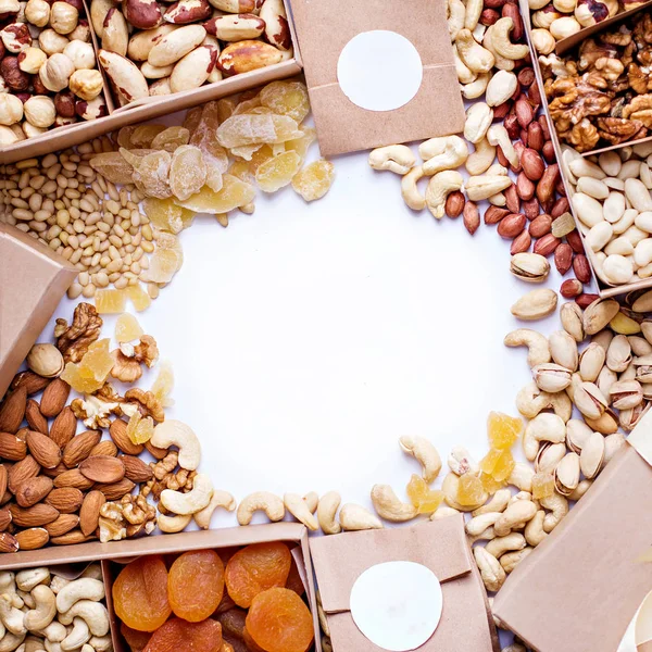 Nuts and dried fruits in the craft package. Photo for the catalog. Place for logo, your text. Background of nuts. (walnut, brazil nut, pecan, pistachios, almond, macadamia, peanut, cashew, hazelnut)