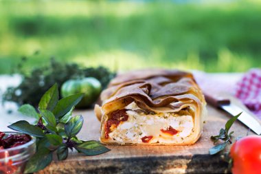 Peynir ve kurutulmuş domates ile meyveli turta. Akşam yemeği için sofrayı. Öğle Yemeği. Ev yapımı pasta, turta ve aperatifler, sebze, meyve, peynir.