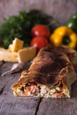 Ev yapımı tavuk, peynir ve eski bir ahşap masa üzerinde beyaz soslu sebze meyveli turta. Rustik tarzı.