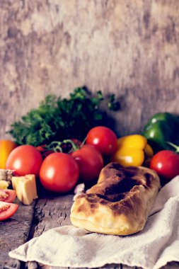 Ev yapımı tavuk, peynir ve eski bir ahşap masa üzerinde beyaz soslu sebze meyveli turta. Rustik tarzı.