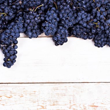 Beyaz tahtalarda mavi üzümler. Üzümlü arka plan, Top view, yakın plan. Metnin için yer.