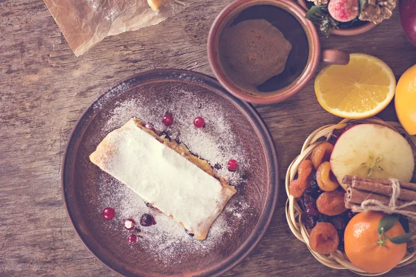 meyveli turta ve kış dekor. Apple strudel (pasta) kurutulmuş meyve, portakal, kızılcık, ceviz ve pudra şekeri ile. Rustik tarzı.