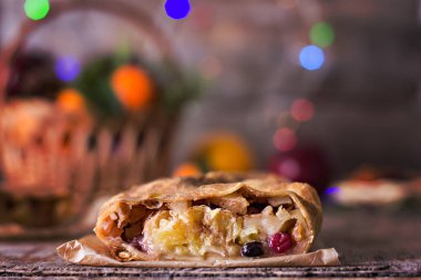 meyveli turta ve kış dekor. Apple strudel (pasta) kurutulmuş meyve, portakal, kızılcık, ceviz ve Noel dekorasyonu ile pudra şekeri. Kış dekor. Rustik tarzı.