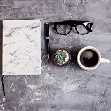 Not defteri, günlük, Gözlük, cep telefonu, kahve, çimento zemin üzerine sulu ile Resepsiyon çalışma alanı. İş natürmort. İş kavramı. düz yatıyordu, en iyi görünümü