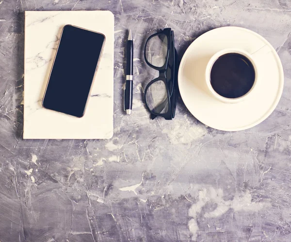 Schreibtischarbeitsplatz Mit Notizblock Tagebuch Brille Handy Kaffee Sukkulente Auf Zementhintergrund — Stockfoto