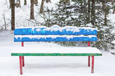 Tezgah kışın karda. Karda bir park bankında, basit resim. 