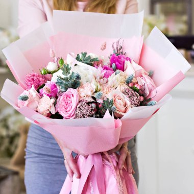 Güzel buket gül desenli ve ve Düğünçiçeği çiçek pembe kadın elinde kağıt ambalaj. Gül ve diğer hassas güzel çiçekler.