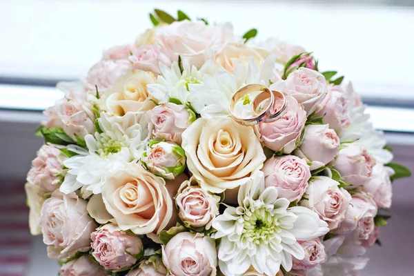 Wedding bouquet with roses and wedding rings