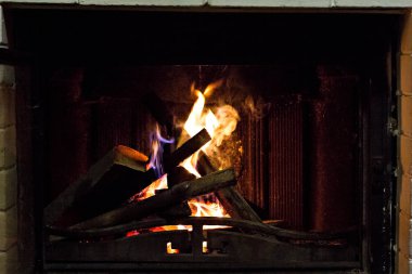 Evde rahat bir şöminede yanan odun. Burns Şöminede ateş. Kış ve Yılbaşı tatil kavramı.
