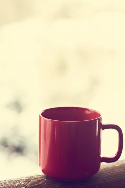 Kahve bardağı, çay kış manzara arka plan üzerinde. Kış orman bir fincan sıcak bir içecek arka planda ile. Masanın içinde belgili tanımlık kış açık. Kış zaman kavramı.