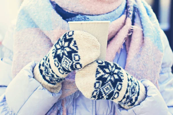 女性双手戴着白色和黑色的手套 拿着热气腾腾的一杯热咖啡可可 美酒或茶 冬季时间概念 在寒冷中晒晒霜 戴手套的妇女手拿着一个工艺纸玻璃 — 图库照片