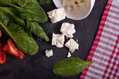 ıspanak, peynir ve domates karanlık bir tablo.