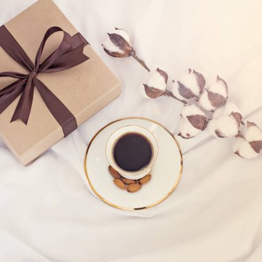 Pamuk şube, hediye ve kahve. Hediye, kahve, pamuk şube. Göndermek için bir kalp ve bir hediye ve bir pamuk dal bir kutusu olan bir zarf. Sevgililer günü veya kadın gün ya da anneler günü için kavram.