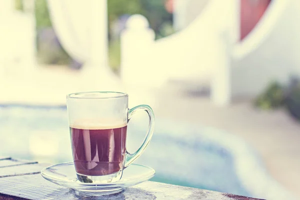 Een kopje espresso en een zwembad op de achtergrond. Koffie in de ochtend. Zomer ontbijt. — Stockfoto