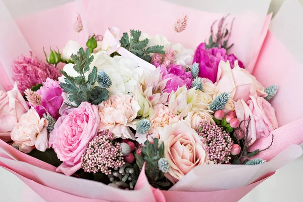 Όμορφη ανθοδέσμη σε ροζ χαρτί περιτυλίγματος. Τριαντάφυλλα και άλλα όμορφα λεπτή λουλούδια. — Φωτογραφία Αρχείου