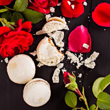 Beyaz badem kurabiyeleri ve koyu arkaplanda kırmızı güller