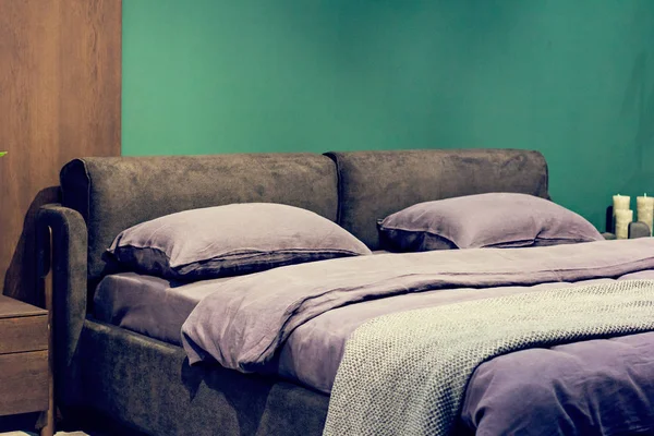 Yatak, gri-beyaz çarşaflarla yapılmış yatak — Stok fotoğraf