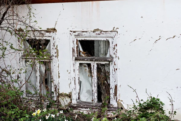 A fachada de uma casa muito antiga. Casa abandonada. Janelas antigas . — Fotografia de Stock