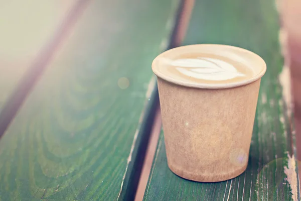 Caffè cappuccino in tazza di carta sul vecchio tavolo di legno — Foto Stock