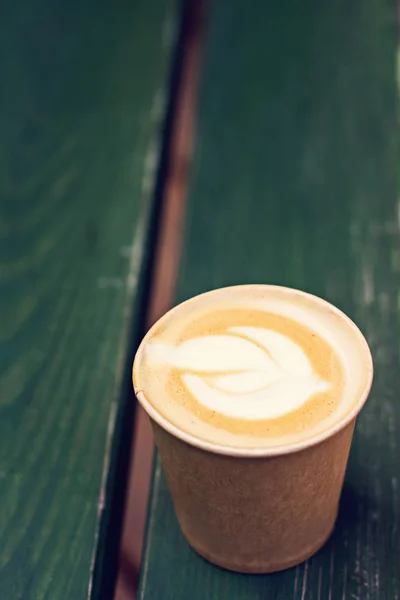 Café capuchino en taza de papel sobre la mesa vieja de madera —  Fotos de Stock