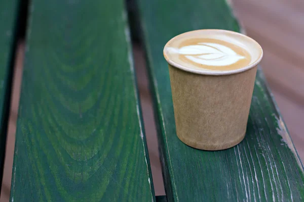 Café capuchino en taza de papel sobre la mesa vieja de madera — Foto de Stock