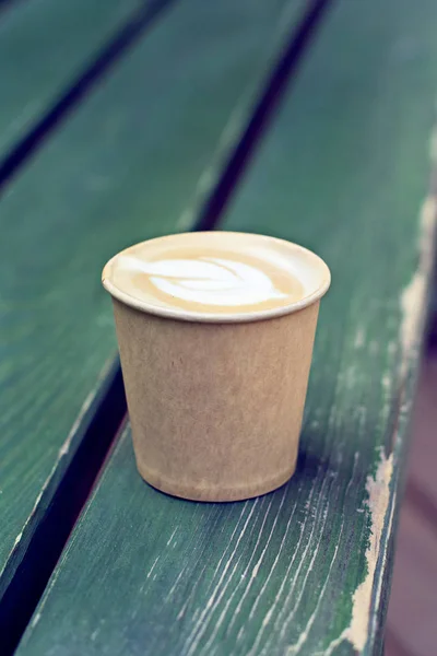 Café capuchino en taza de papel sobre la mesa vieja de madera —  Fotos de Stock