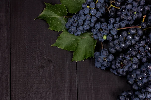 Blue grapes on black old boards. Background with grapes, Top view, closeup. Place for your text. — Stock Photo, Image