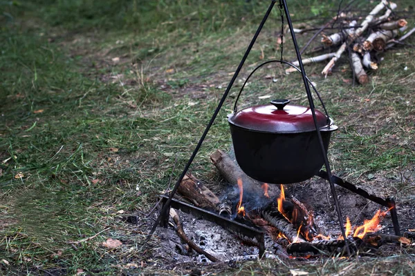 A pot of meat over a fire. Hike, summer vacation, outdoor recreation, outdoor food. Cooking over a campfire. tourist kettle over campfire.