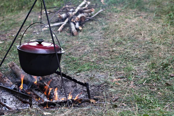 Горшок мяса на костре. Прогулки, летние каникулы, отдых на свежем воздухе, еда на открытом воздухе. Готовить у костра. туристический чайник у костра . — стоковое фото