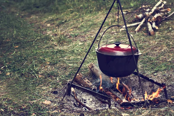 A pot of meat over a fire. Hike, summer vacation, outdoor recreation, outdoor food. Cooking over a campfire. tourist kettle over campfire.