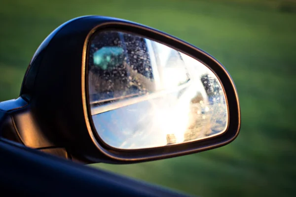 車の中でサイドミラー 鏡の中の夕日の反射 バックミラーで日没 高速道路の近代的な車 — ストック写真