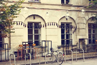 Çiçekli rahat bir sokak kafesi. Kafe masaları olan rahat bir cadde. Mimari ve simgeler.