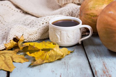Balkabağı, yaprak, battaniye ve tahtaların üzerinde kahve ile sonbahar kompozisyonu. Sıcak bir sonbahar. Sonbahar sakin bir hayat.