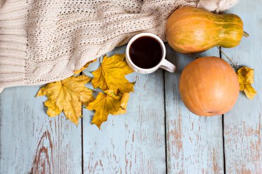 Balkabağı, yaprak, battaniye ve tahtaların üzerinde kahve ile sonbahar kompozisyonu. Sıcak bir sonbahar. Sonbahar sakin bir hayat.