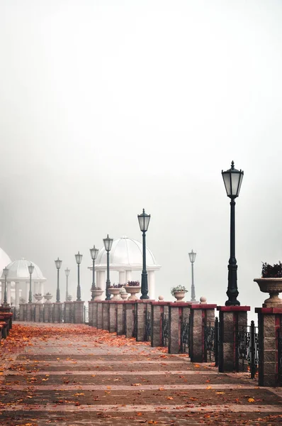 Οδός ανάχωμα με φανάρια σε ομίχλη το φθινόπωρο. Aytumn. — Φωτογραφία Αρχείου