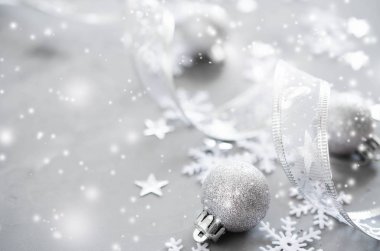 Gümüş Noel arka plan. Kıvırcık kurdele ile dekoratif topları ve kar taneleri. Xmas süslemeleri. Kopya alanı, kar etkisi.