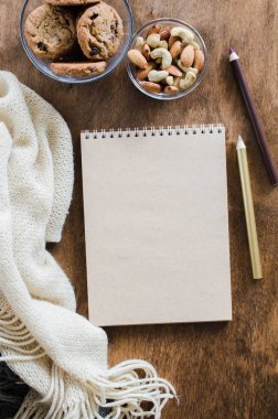 Düz örme battaniye ve ahşap masa snacks boş kahverengi defter yatırın. Sonbahar ya da kış ruh rahat. Kopya alanı.