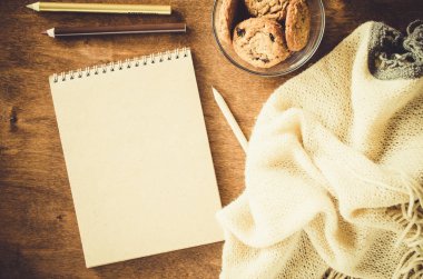 Düz örme battaniye ve ahşap masa snacks boş kahverengi defter yatırın. Sonbahar ya da kış ruh rahat. Kopya alanı.