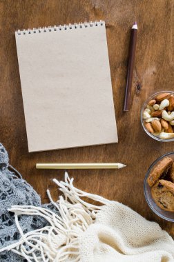 Düz örme battaniye ve ahşap masa snacks boş kahverengi defter yatırın. Sonbahar ya da kış ruh rahat. Kopya alanı.